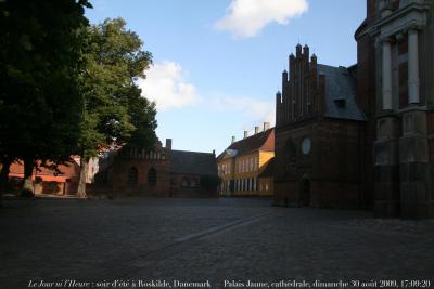 photographie “Le Jour ni l\'Heure 6129 : soir d\'été à Roskilde, Seeland (Sjælland), Danemark — le Palais Jaune, 1733-1736, au centre, et le transept nord de la cathédrale, dimanche 30 août 2009, 17:09:20” par Renaud Camus — www.renaud-camus.net — cathedral, Absalon, évêque, bishop, rois, kings, kongs, monarchie, monarchy, Sjælland, Denmark, Danmark, palace, yellow, classicisme, classicism, Thurah, Lauritz de Thurah, abside, palce, square