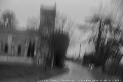 photographie “Le Jour ni l’Heure 4129 : La place du mort — Magnas, Gers, samedi 18 avril 2015, 20:26:51” par Renaud Camus — www.renaud-camus.net — La Place du mort, Magnas, église de Magnas, Gers, Gascogne, pluie