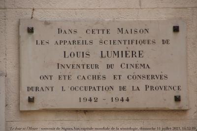 photographie “Le Jour ni l’Heure 6913 : plaque sur une maison de Signes, Var, Provence, dimanche 11 juin 2023, 14:52:19” par Renaud Camus — www.renaud-camus.net — Signes, Var, Provence, Lumière, Louis Lumière, instruments, instruments scientifiques, Occupation, Première Occupation, cinéma, cinématographe, dimanche 11 juin 2023