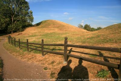 photographie “Le Jour ni l\'Heure 8539 : Ombres de voyageurs avec des tertres funéraires suèves, Gamla Uppsala, Uppland, jeudi 22 juillet 2010, 19:04:51” par Renaud Camus — www.renaud-camus.net — shadows, tombeaux, Sverige, Sweden, Pierre