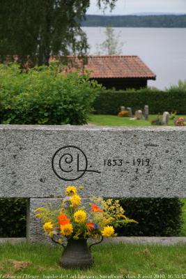 photographie “Le Jour ni l\'Heure 0048 : tombeau du peintre Carl Larsson, 1853-1919, avec son monogramme, cimetière de Sundborn, Dalécarlie (Dalarna), Suède,  dimanche 8 août 2010, 16:35:47” par Renaud Camus — www.renaud-camus.net — tomb, grave, churchyard, lac, lake, Sverige, Sweden, painter, artiste, artist