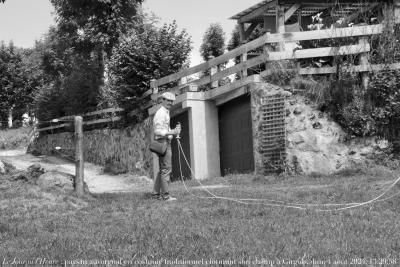 photographie “Le Jour ni l’Heure 0269 : paysan auvergnat en costume traditionnel occupé à clôturer son champ, Girgols, Cantal, dimanche 4 août 2024, 13:29:58” par Renaud Camus — www.renaud-camus.net — paysan auvergnat en costume traditionnel, Auvergne, paysan, casquette, homme, moustache, Girgols, Cantal, Haute-Auvergne, Pierre, 1er août 2024