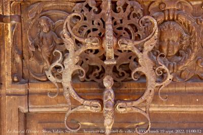 photographie “Le Jour ni l‘Heure 8936 : Sion, Valais, Suisse — heurtoir de l‘hôtel de ville, c. 1660, lundi 19 septembre 2022, 14:00:12” par Renaud Camus — www.renaud-camus.net — heurtoir, Sion, Valais, Suisse, hôtel de ville, heurt, hôtel de bourgeoisie, bourgeoisie, porte